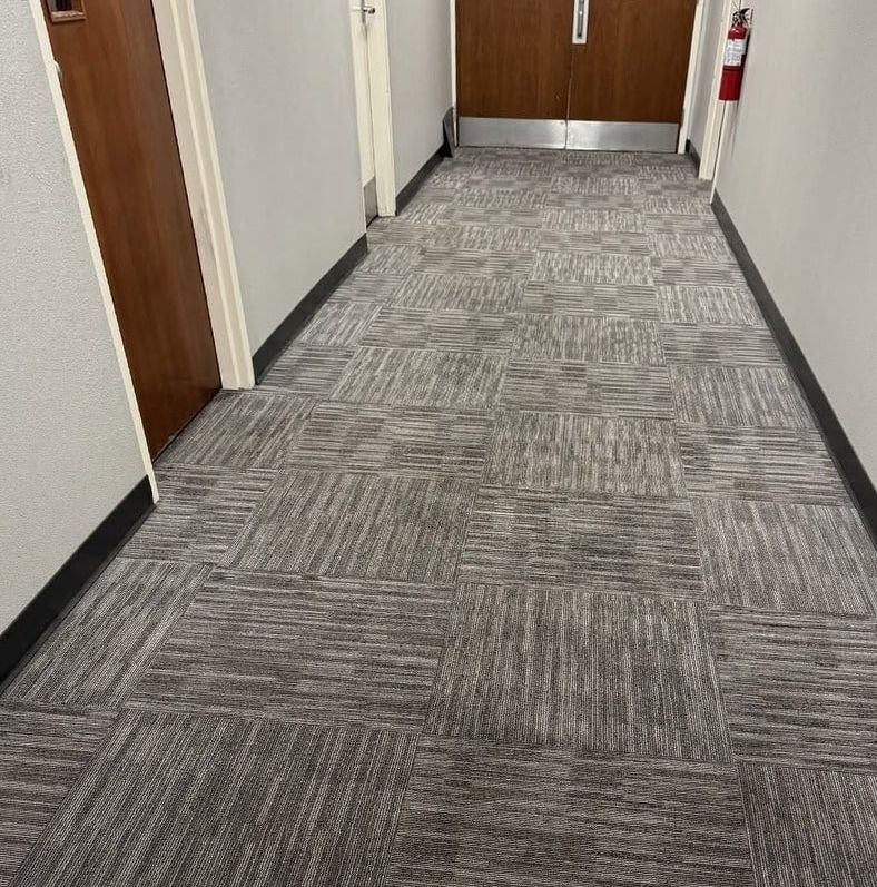 The same hallway carpet tiles even and clean, with the traffic lane gone