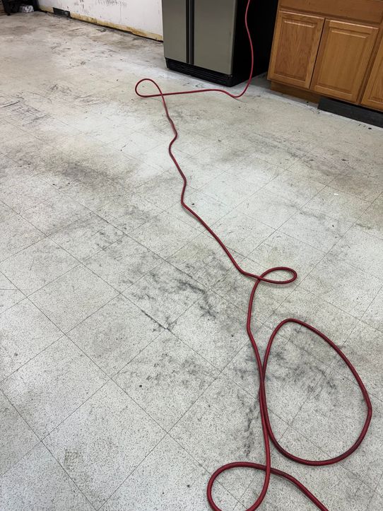 Scuffed, grimy white vinyl composition tile in a business's back room