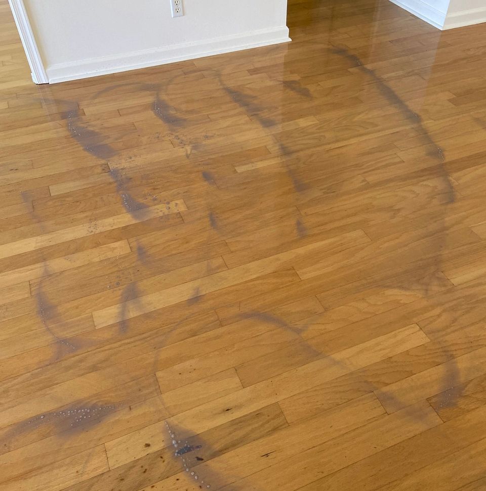 Hardwood floor with hazy mop streaks and dark smudges before cleaning