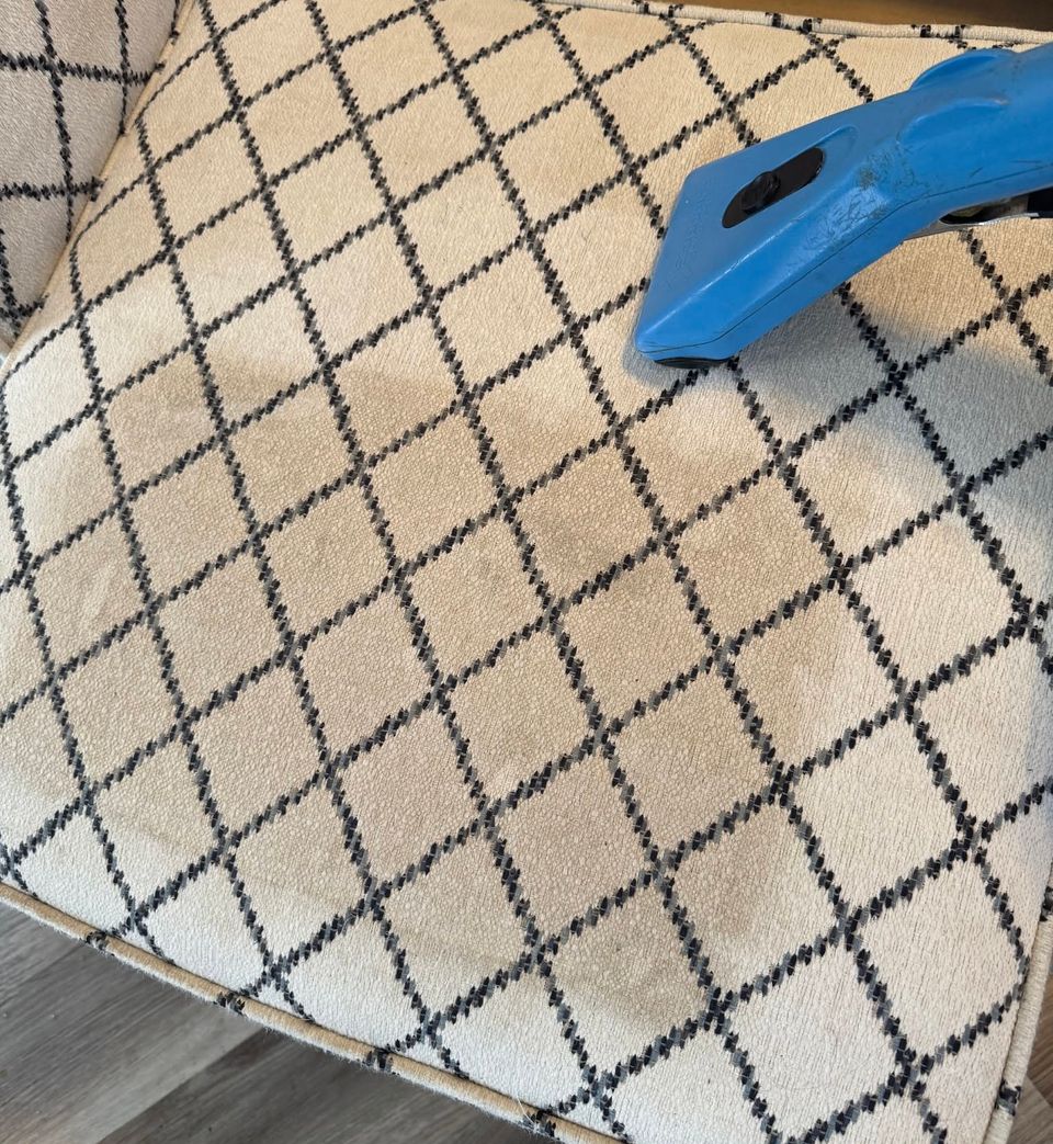 Mark's upholstery tool partway across a cream chair cushion with a navy lattice pattern